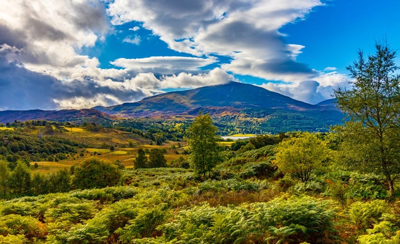 A foggy, remote Scottish highland landscape with a distant loch.