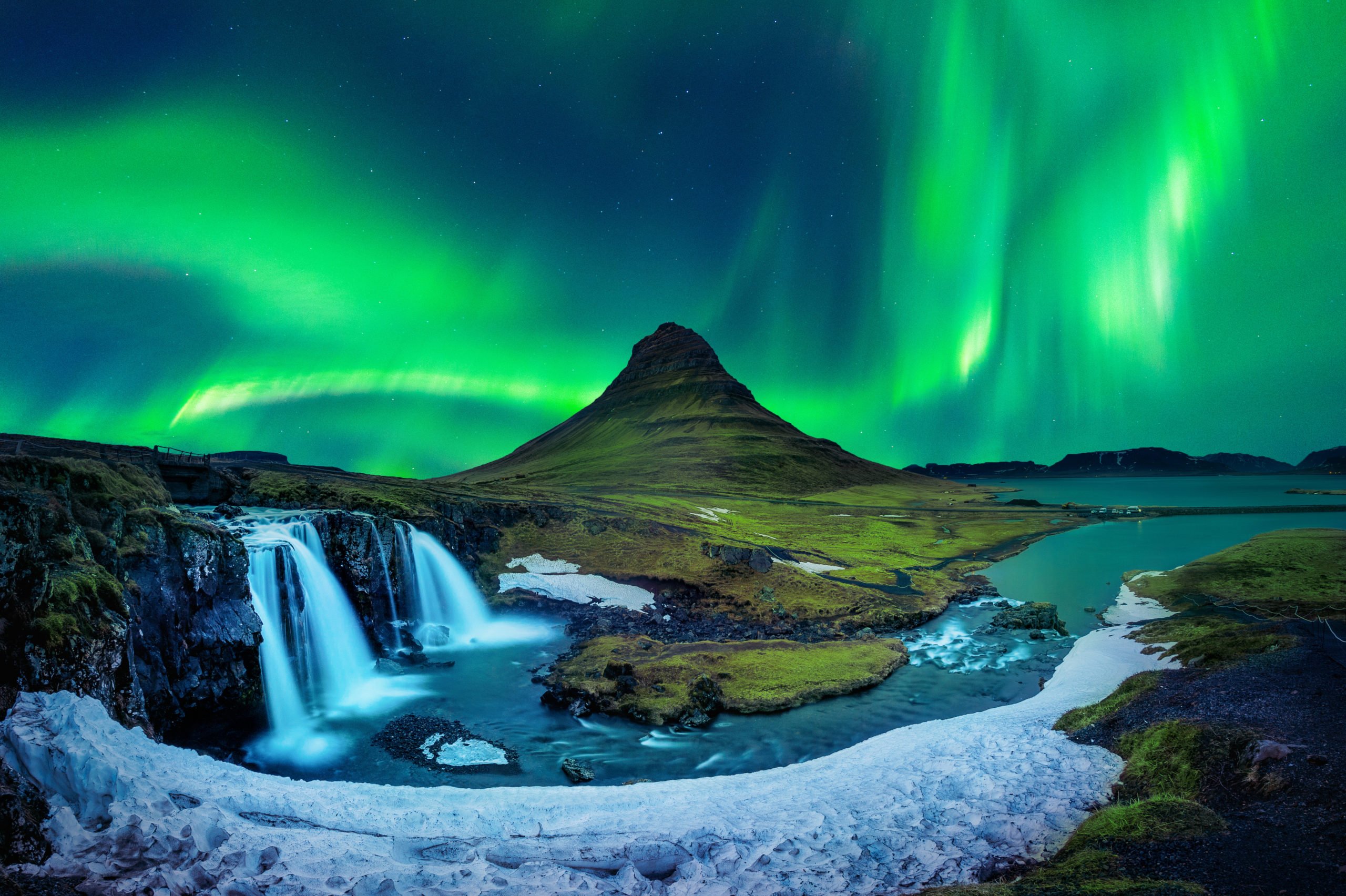 A stunning view of the green and pink Aurora Borealis over an Icelandic glacier.